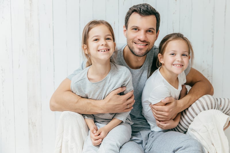 Happy father embracing his two daughters